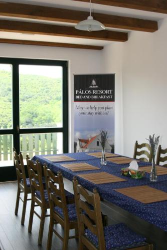 a dining room with a blue table and chairs at Pálos Resort in Zalacsány