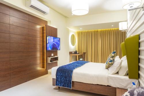 een hotelkamer met een bed en een flatscreen-tv bij Krishna Palace Hotel in Bhayandar
