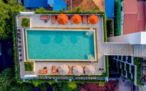 an overhead view of a swimming pool with orange umbrellas at Penh House Hotel in Phnom Penh