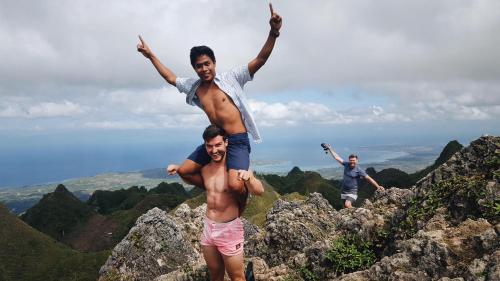 two men standing on top of a mountain with their arms in the air at Murals Hostel and Cafe in Cebu City