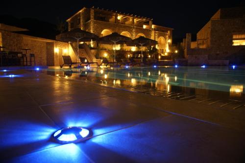 a swimming pool at night with blue lights on it at Anaxo Resort in Riglia