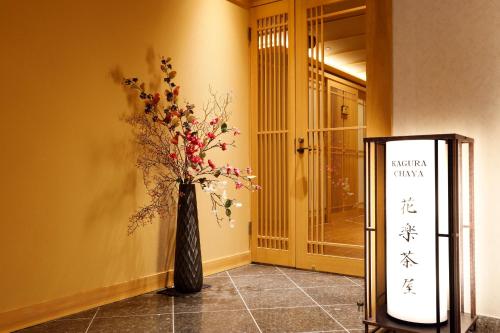 a black vase with flowers in a hallway at Kasuitei Ooya in Fujikawaguchiko