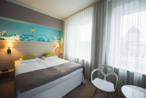 a hotel room with a bed and a window at Hotel Cristal Białystok in Białystok