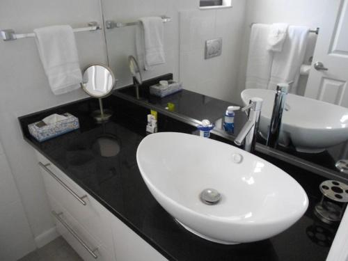 a bathroom with a white sink and a black counter at Foxrun Retreat - 3BR Inverness Poolhome in Inverness