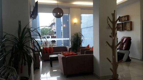 a living room with couches and plants in a building at Geopark Hotel Kuah Langkawi in Kuah