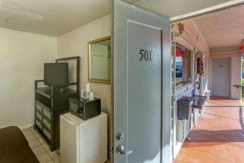 a room with a door with a television and a refrigerator at Richard's Hotel in Hollywood