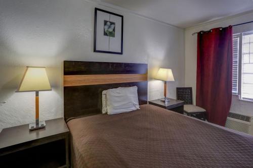 a bedroom with a large bed with two lamps at Richard's Hotel in Hollywood
