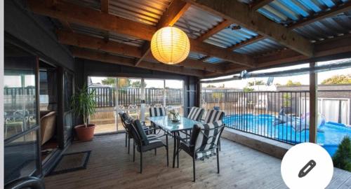 a patio with a table and chairs and a pool at Skyline SkyRides Premium Property in Rotorua