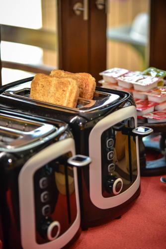 a black and white toaster with bread and toast at Mhonsa Hotel in Chiang Mai