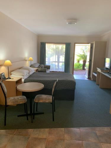 a hotel room with a bed and a table and chairs at Arthur Phillip Motor Inn in Cowes