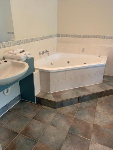 a bathroom with a tub and a sink at Arthur Phillip Motor Inn in Cowes