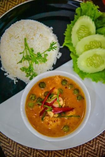a plate of food with a bowl of soup and rice at Mhonsa Hotel in Chiang Mai