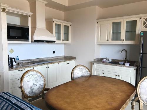 une cuisine avec des armoires blanches et une table et des chaises dans l'établissement Imperial Condotel, à Vung Tau