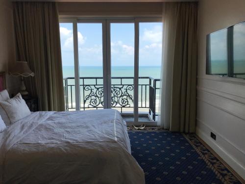 une chambre d'hôtel avec un lit et un balcon dans l'établissement Imperial Condotel, à Vung Tau