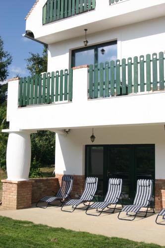 four chairs sitting in front of a house at Pálos Resort in Zalacsány