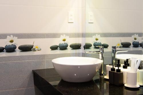a bathroom with a sink and vases with flowers at Kim Phu Villa Hoi An in Hoi An