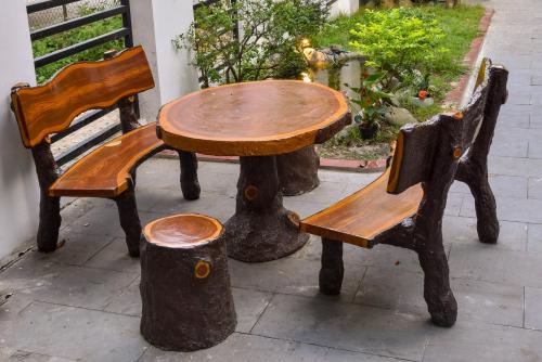 a wooden table and two chairs and a table and bench at Kim Phu Villa Hoi An in Hoi An