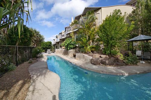 a swimming pool in front of a building at Andari Holiday Apartments in Sunshine Beach