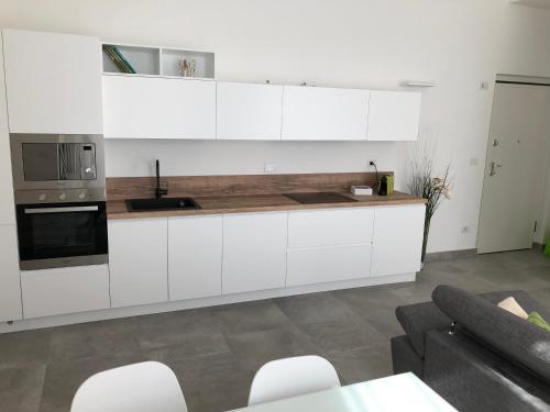 uma cozinha com armários brancos e electrodomésticos brancos em JOE LUXURY HOUSE em Turim