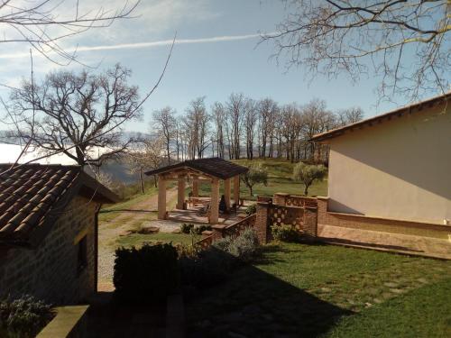 a gazebo in a yard next to a building at Agriturismo Il Beccafico Alpaca in Mengara