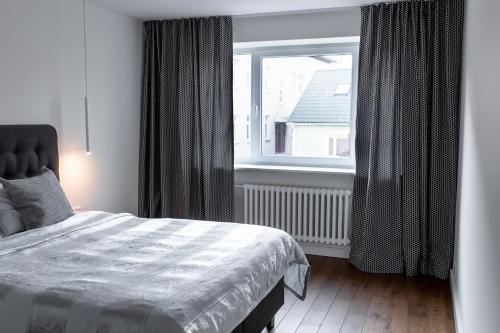 Un dormitorio con una cama y una ventana grande. en Supeluse-Strassel Beach Apartment, en Pärnu