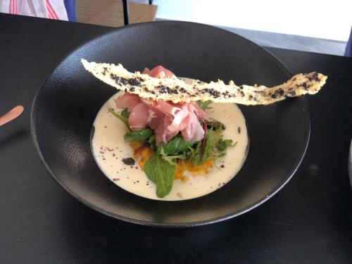 a black bowl with a plate of food on a table at Hôtel des Mosaiques in Orbe