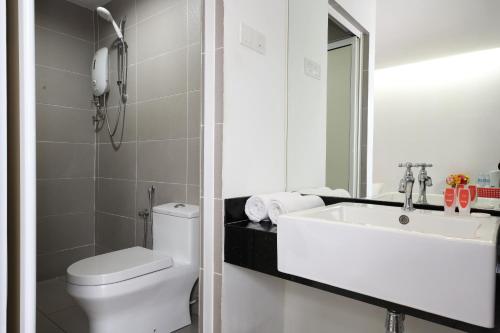 a bathroom with a sink and a toilet and a mirror at V Garden Hotel in Kuala Lumpur