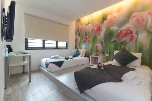 1 dormitorio con 2 camas con flores rosas en la pared en V Garden Hotel, en Kuala Lumpur