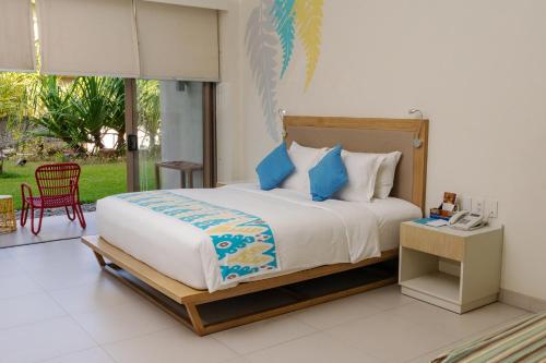 a bedroom with a large bed with blue pillows at Costa Pacifica Baler in Baler