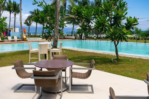 una mesa y sillas frente a una piscina en Costa Pacifica Resort, en Baler