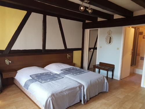 a bedroom with a large bed with white sheets at Au Cep de Vigne in Riquewihr