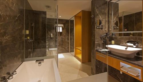 a bathroom with a tub and a sink and a shower at Golden Premier Amritsar in Amritsar