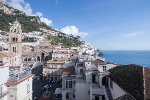 a group of buildings on a hill next to the ocean at Zia Pupetta Suites in Amalfi