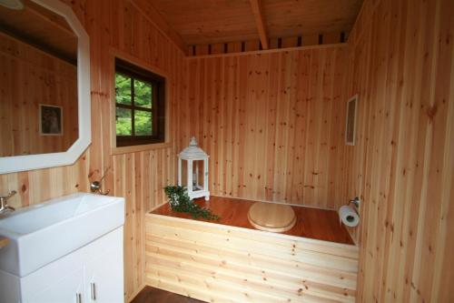 a bathroom with a tub in a wooden cabin at Insel Korsnäsudden in Hagfors