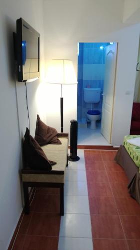 a room with a couch and a tv and a bathroom at Villa Mar Bella in Costinesti