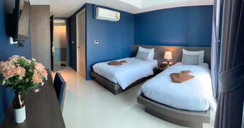 a hotel room with two beds and a tv at The Seens Hotel in Krabi
