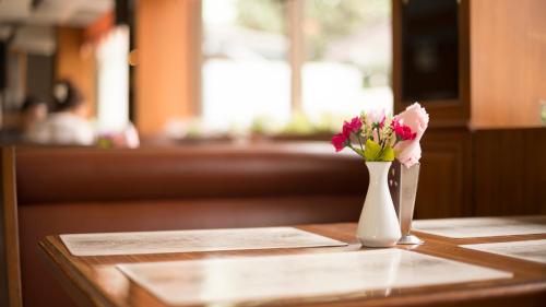 a vase of flowers sitting on top of a table at Siam Palace Hotel in Bangkok