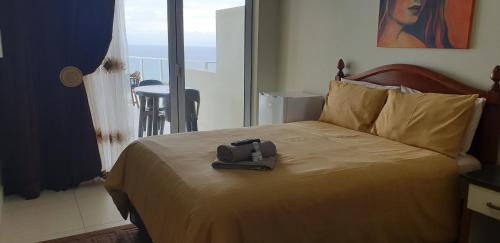 a hotel room with a bed with a bag on it at The Homestead Margate - South Africa in Margate
