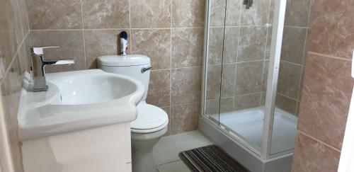 uma casa de banho com um WC, um lavatório e um chuveiro em The Homestead Margate - South Africa em Margate