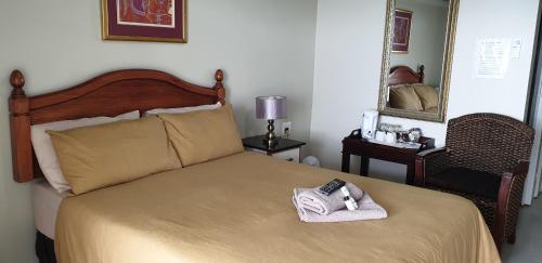 a bedroom with a bed with two towels on it at The Homestead Margate - South Africa in Margate