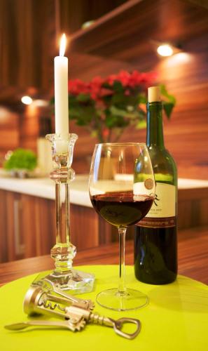 une bouteille de vin, un verre et une bougie dans l'établissement Villa Star, à Międzyzdroje
