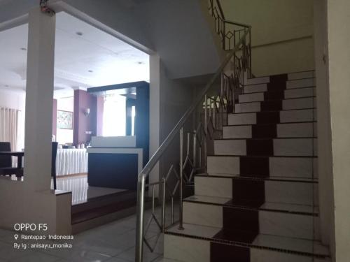 a spiral staircase in a building with a stair railing at Hotel Monika in Rantepao