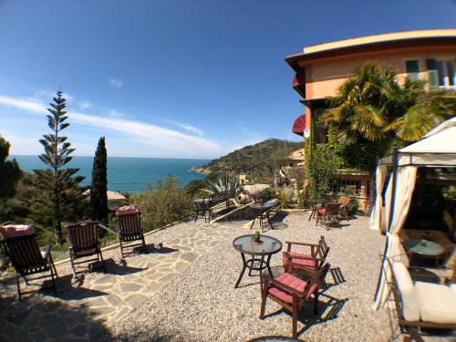 a patio with chairs and a table in front of a building at Hotel Villa Belvedere in Bonassola