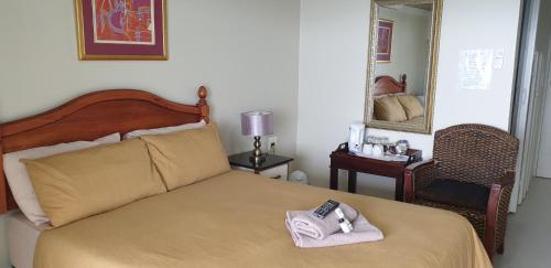 a bed with a towel and a remote control on it at The Homestead Margate - South Africa in Margate
