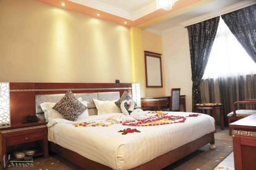 - une chambre avec un grand lit fleuri dans l'établissement Vamos Guest House, à Addis-Abeba