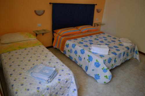 two beds in a hotel room withacers at Antico Borgo in Roseto degli Abruzzi