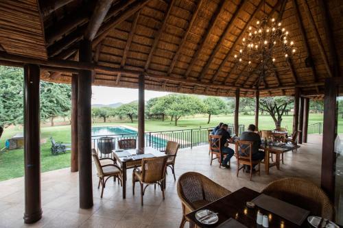 a restaurant with tables and chairs and a chandelier at Lapeng Guest Lodge in Burgersfort