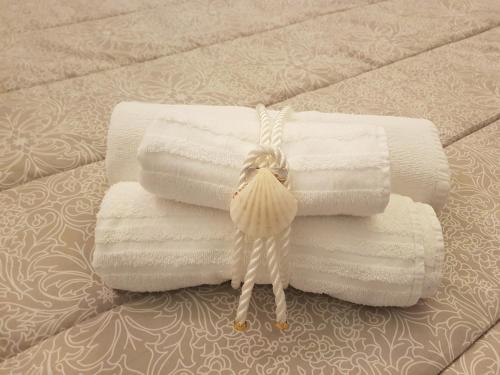 a stack of towels sitting on a bed with a pile of towels at Residenza Lumière in Termoli