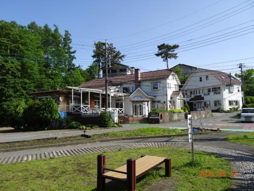 a bench in the grass in front of a house at Resort inn Sakanoshita in Fujikawaguchiko