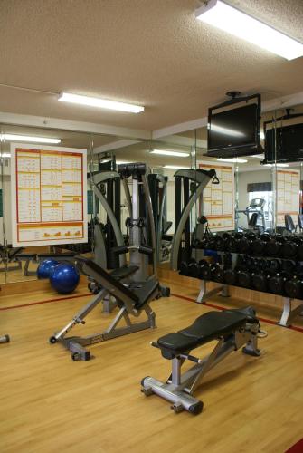 a gym with several tread machines and a television at Anaheim Majestic Garden Hotel in Anaheim